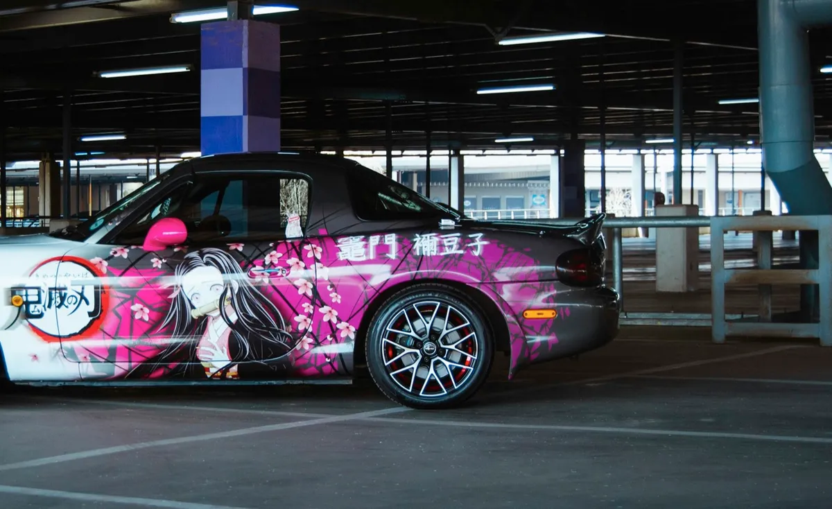 Mazda MX-5 with a pink Demon Slayer vinyl wrap in a car park